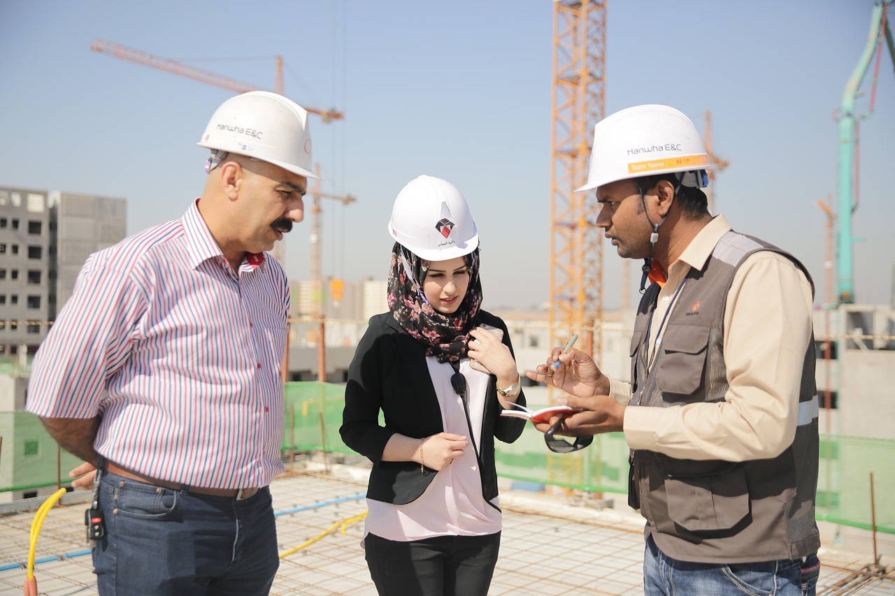Team di architetti e consulenti in cantiere con caschi bianchi