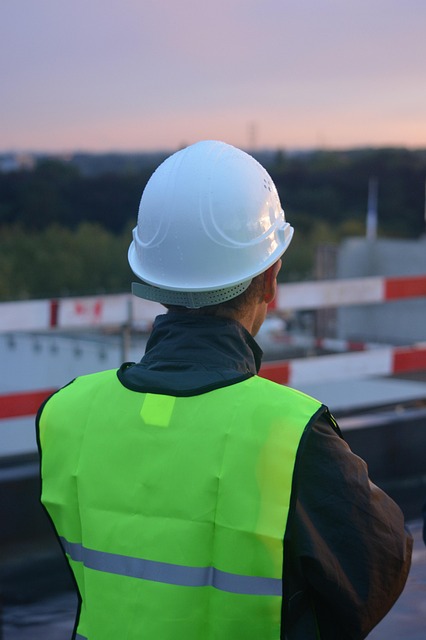 Operaio edile con casco bianco e giubbotto di sicurezza in cantiere