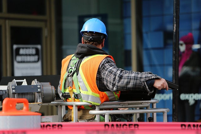 Operaio edile con casco blu e giubbotto di sicurezza in cantiere